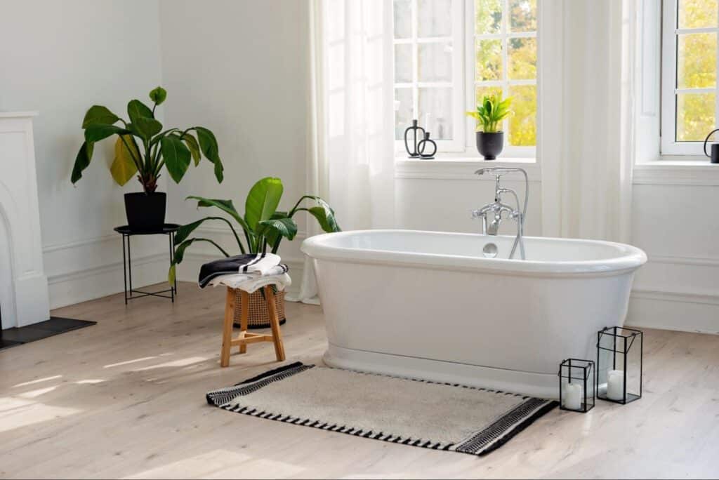 Modern bathroom featuring a stylish freestanding tub and serene plant decor.