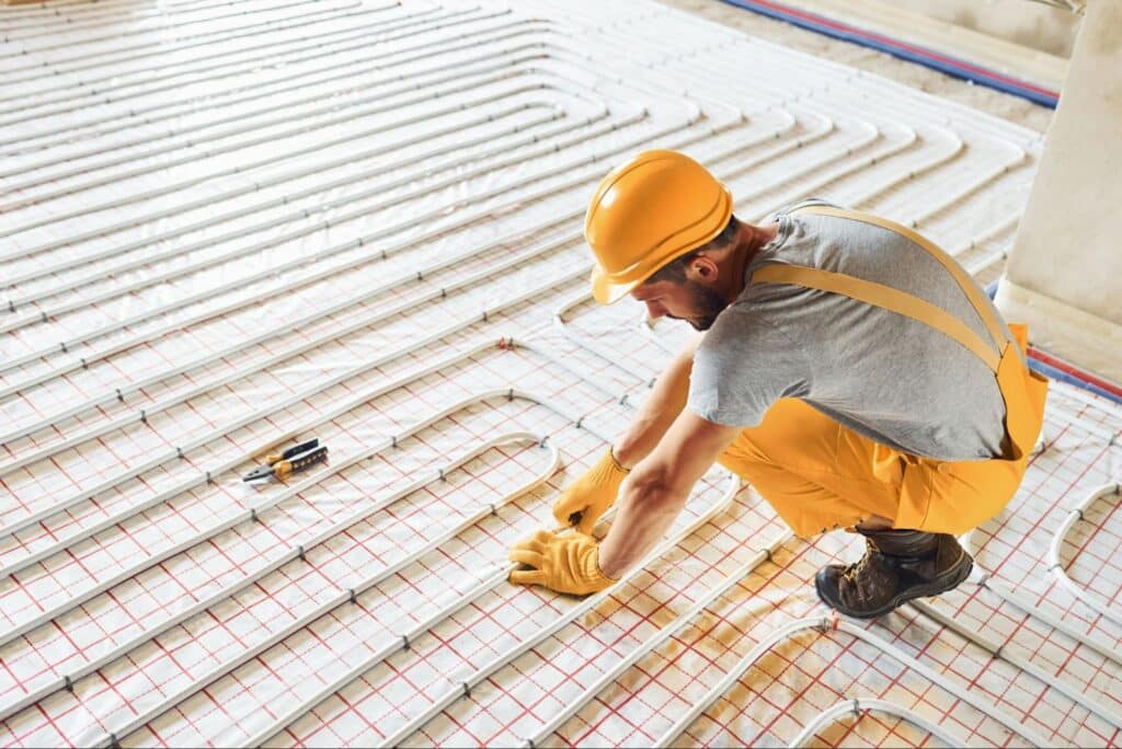 Expert installing in-floor heating system with precision and care.