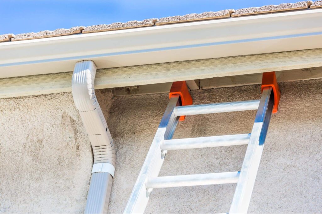 Ladder positioned for gutter installation on a residential building.