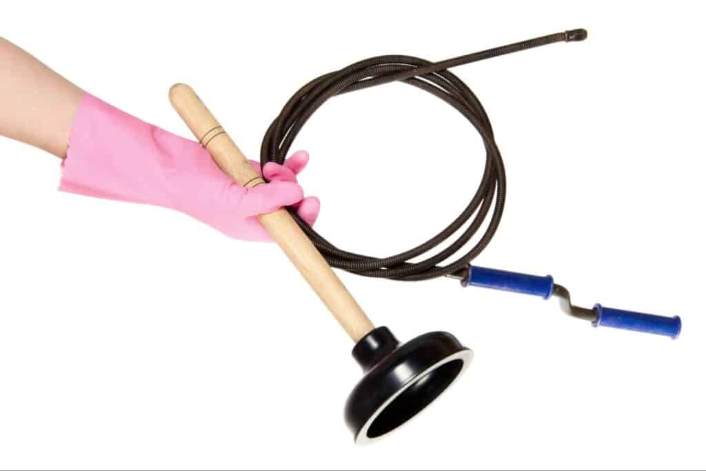 Essential plumbing tools: plunger and snake for effective home drainage solutions.
