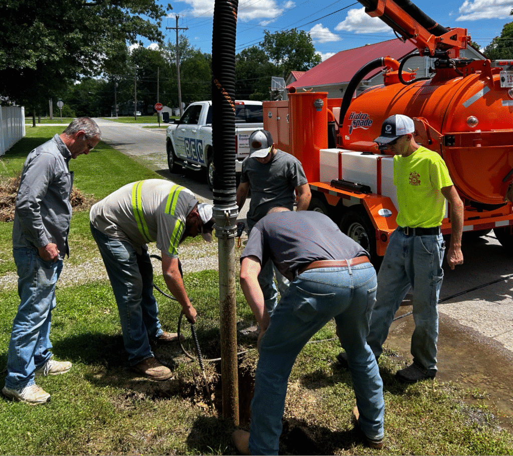 The concept of choosing a plumber with workers using heavy equipment on a plumbing issue.