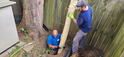 Professional drain cleaning service technicians working to fix a blocked drain.