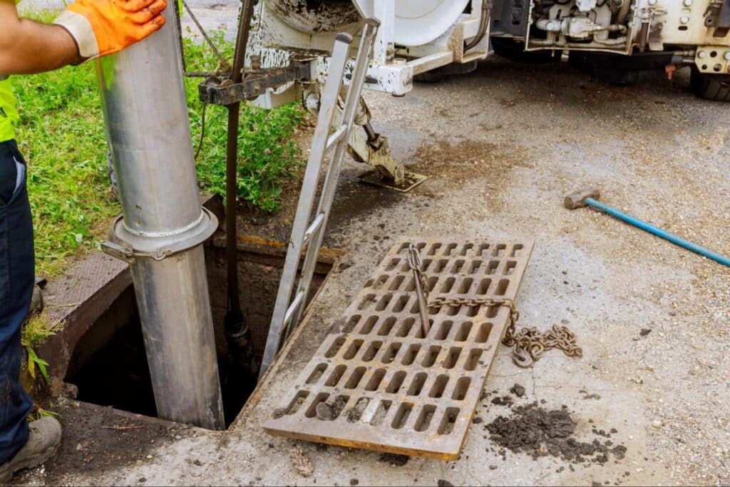 Plumber operating a pipe system at an urban drainage site.