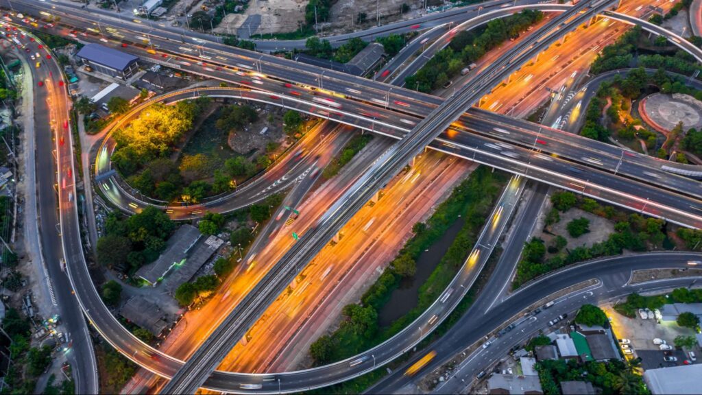 Aerial view of a busy highway interchange illuminated at night.