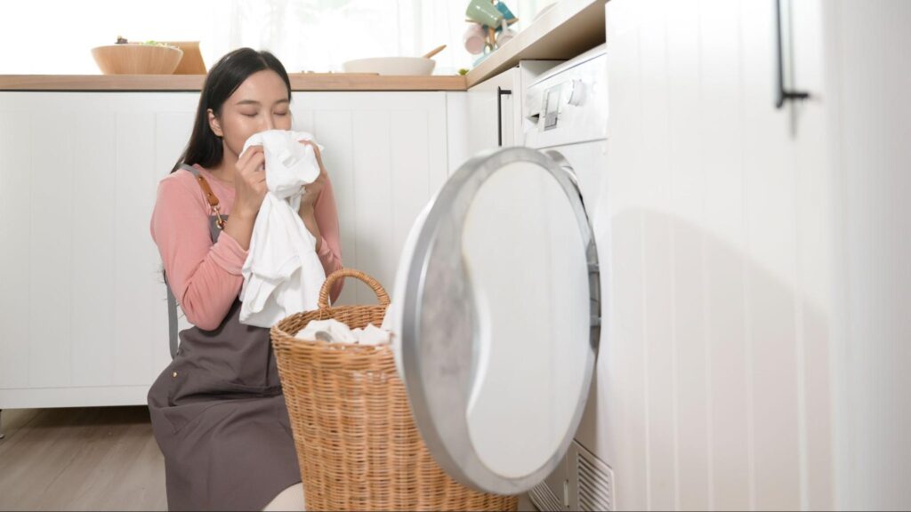Enjoying the refreshing scent of clean laundry in a bright laundry room.