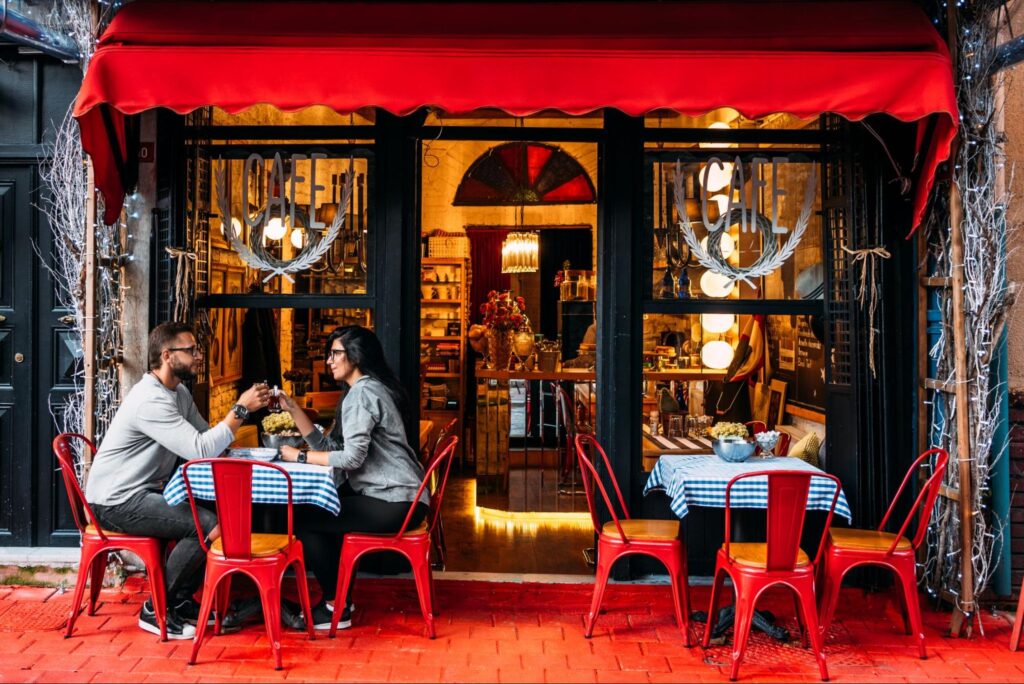 Charming café with red chairs, inviting couples to relax and enjoy their coffee together.