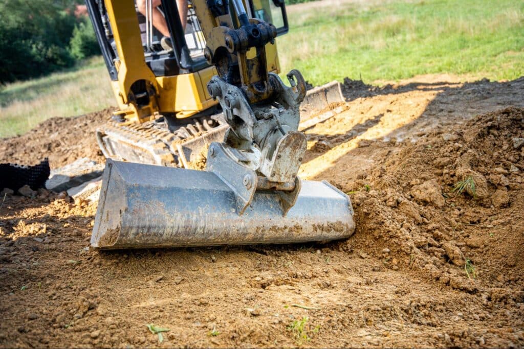 Heavy machinery grading land in preparation for construction and water and sewer line installation