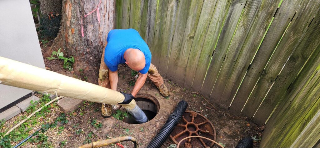 Person performing CIPP storm restoration maintenance in a residential backyard.