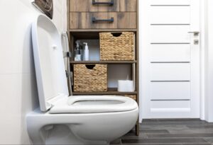 Modern bathroom with sleek toilet, wooden storage, and minimalist design elements.