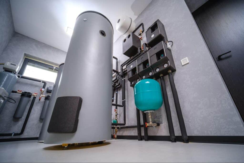 Modern plumbing system featuring a gray tank and water pressure equipment in a utility room.