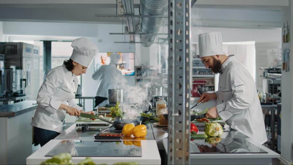 Chefs preparing fresh ingredients in a modern kitchen, showcasing culinary skills and creativity.