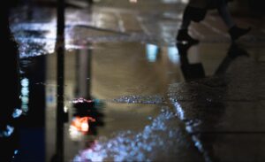 Waterlogged basement floor with standing puddles after flooding.
