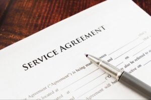 Service agreement document with a silver pen on a wooden surface.