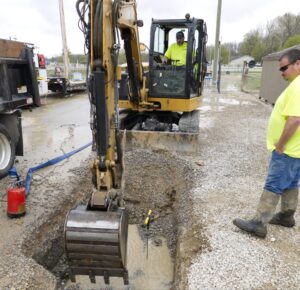 Excavation work in progress with heavy machinery and workers at a construction site.