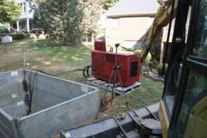 Construction site with a red generator and equipment for excavation work.