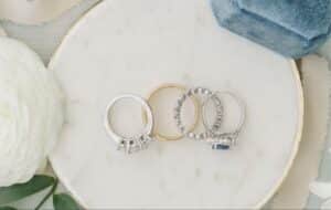 Elegant collection of silver and gold rings displayed on a marble surface.