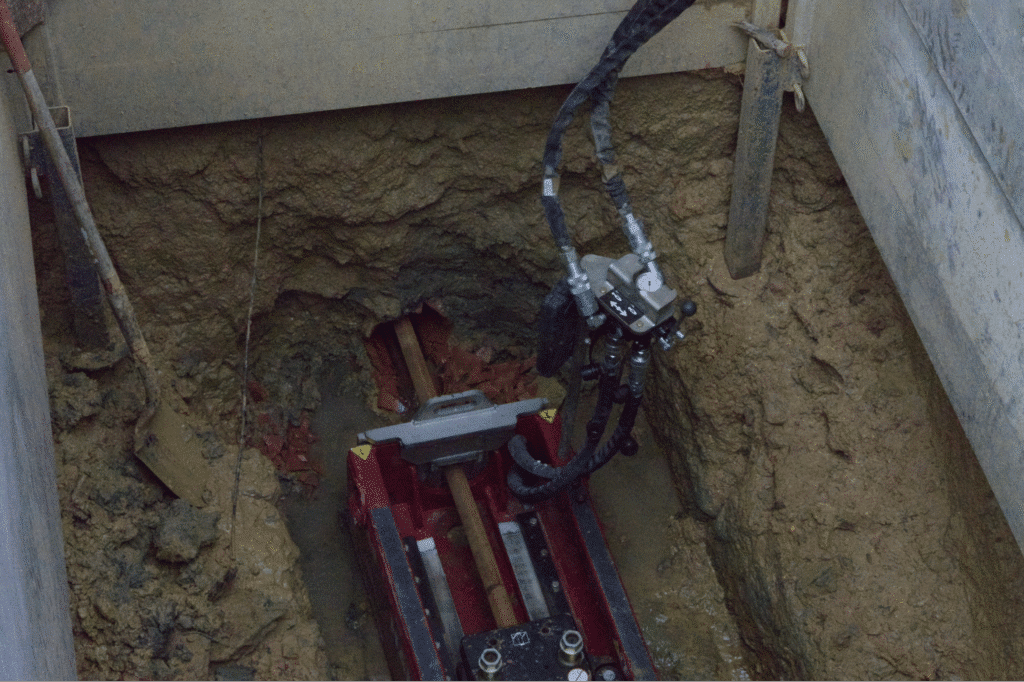 Excavation machinery operating in a trench for underground utility installation.