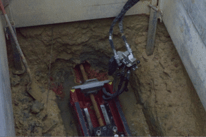 Excavation machinery operating in a trench for underground utility installation.