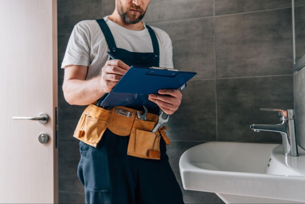 Plumber reviewing bathroom renovation checklist for fixtures and repairs.