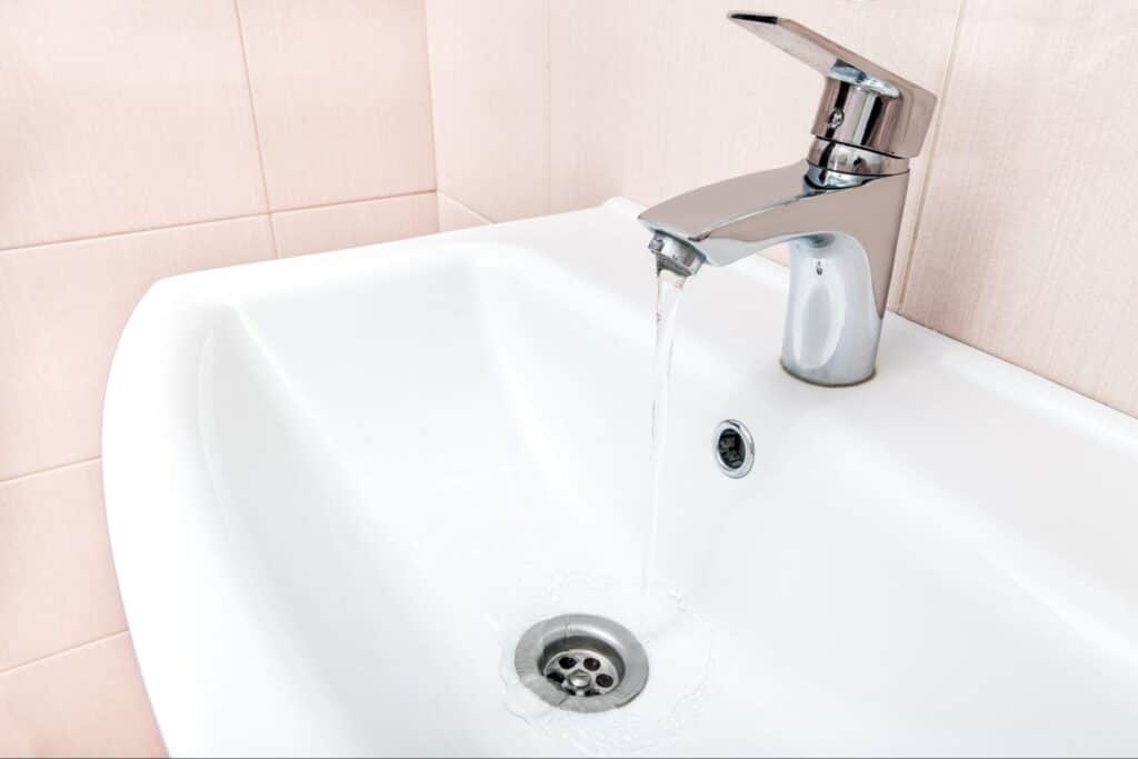 Sleek faucet design with water flowing into a modern white sink.